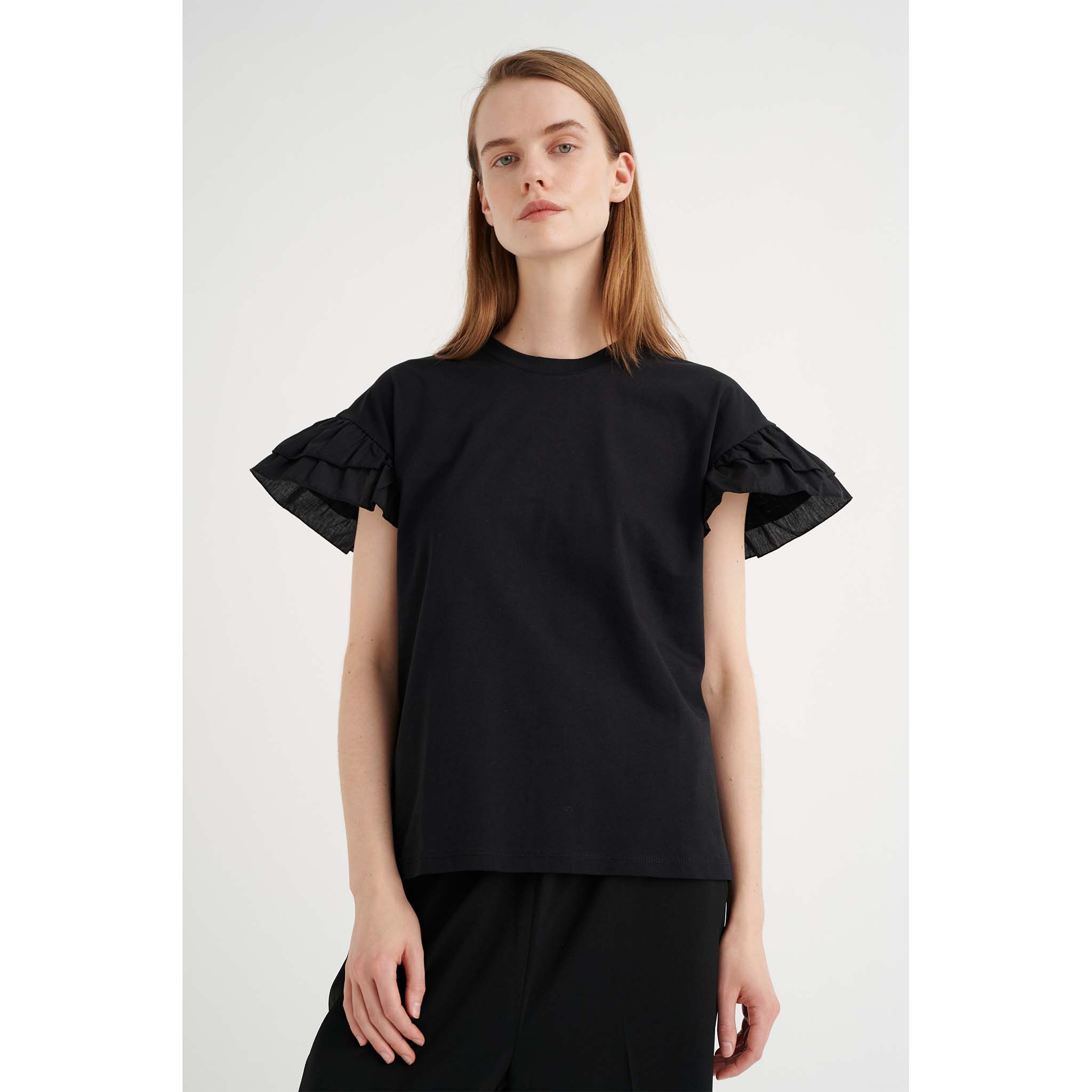 In Wear, musta t-paita, jossa on frilla-hihat. Etukuva mallin päällä.