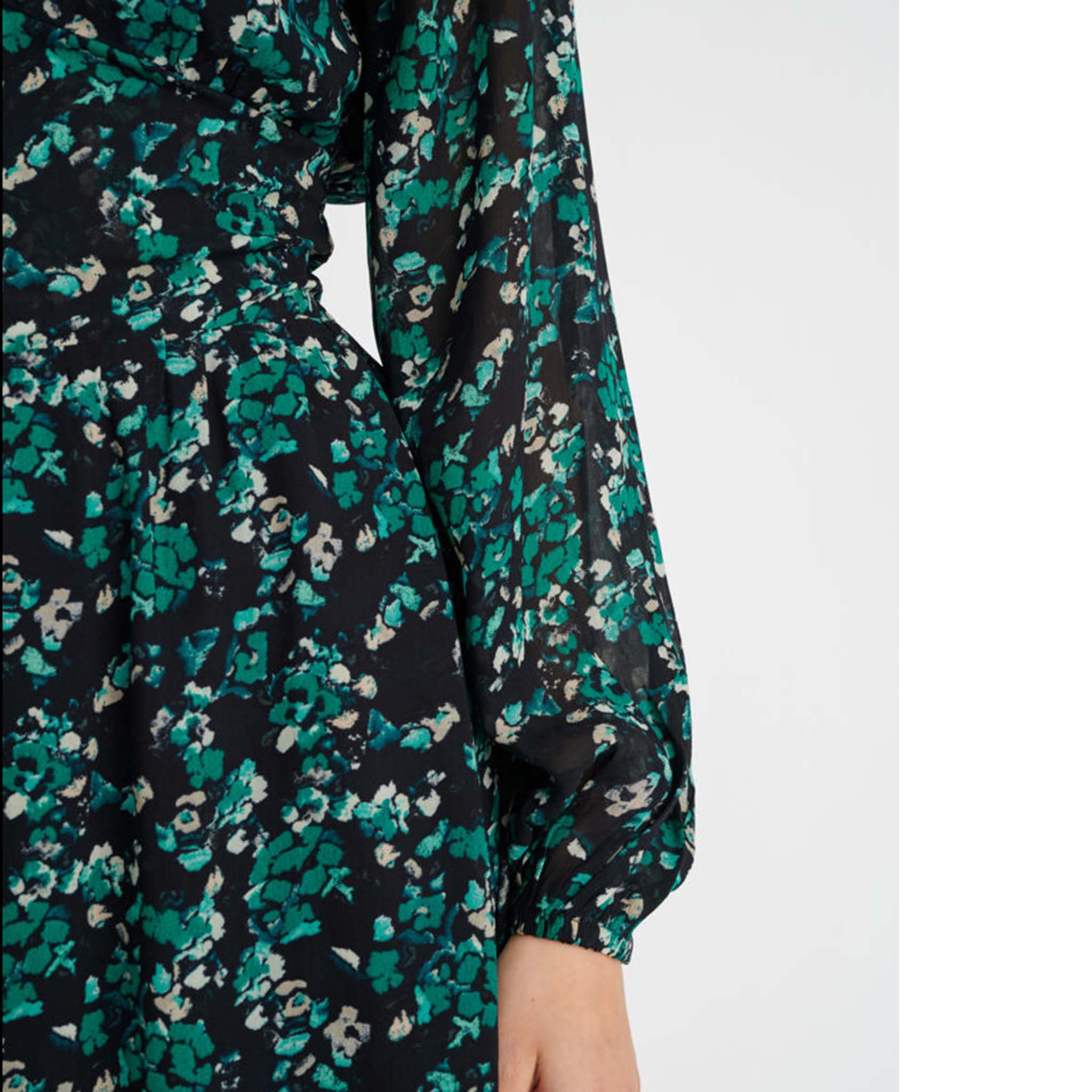 In Wear, pitkähihainen sifonkimekko. Mustalla pohjalla vihreäsävyinen kukka-aihe. Lähikuva mallin päällä.