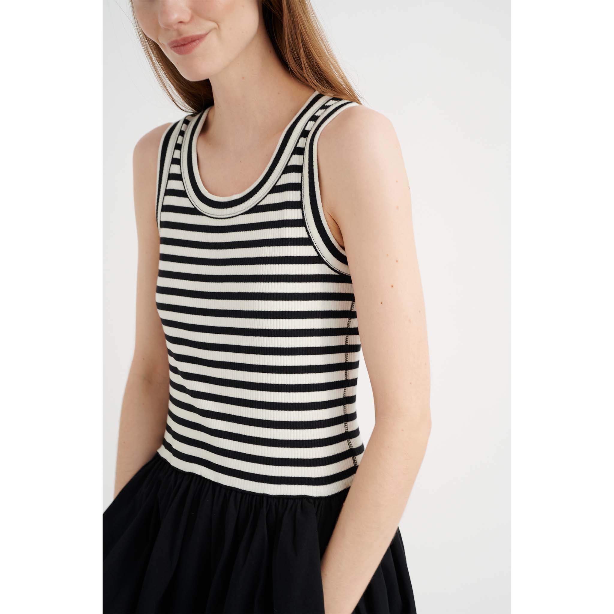 In Wear, mustavalkoinen mekko. Yläosa on mustavalko-raidallinen ja hameosa musta. Lähikuva mallin päällä.