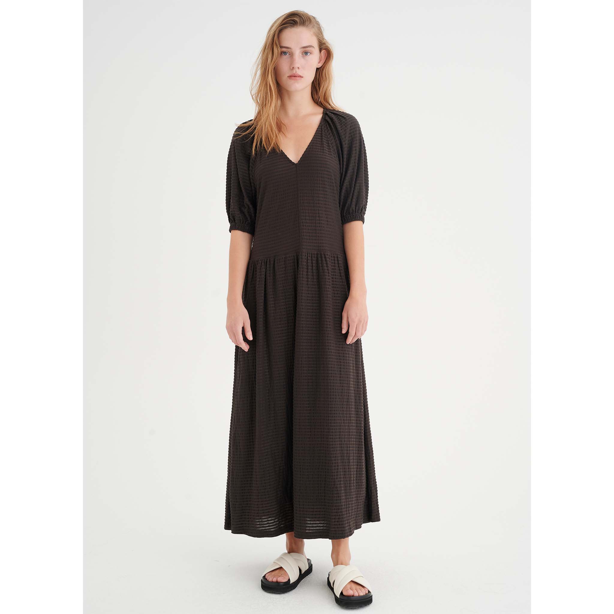 In Wear, tummanruskea, pitkä mekko. Väljät hihat, poimutettu helma. Etukuva mallin päällä.