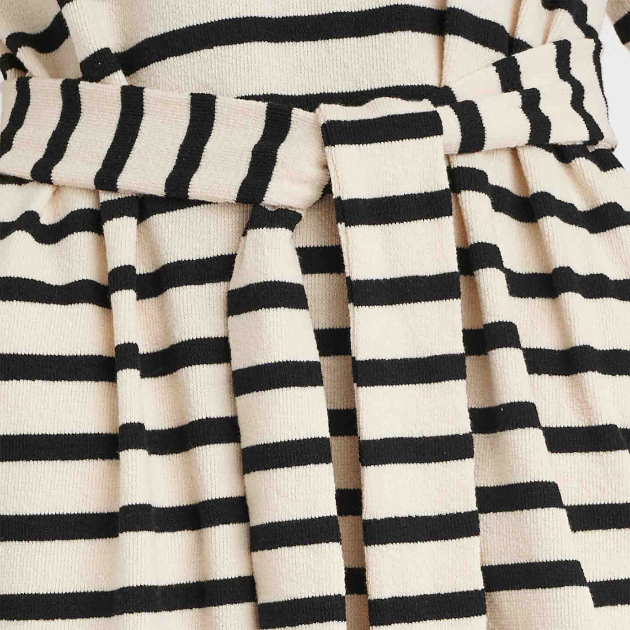 In Wear, pitkä neulemekko. Luonnonvalkoisella pohjalla mustat raidat. Lähikuva kankaasta.