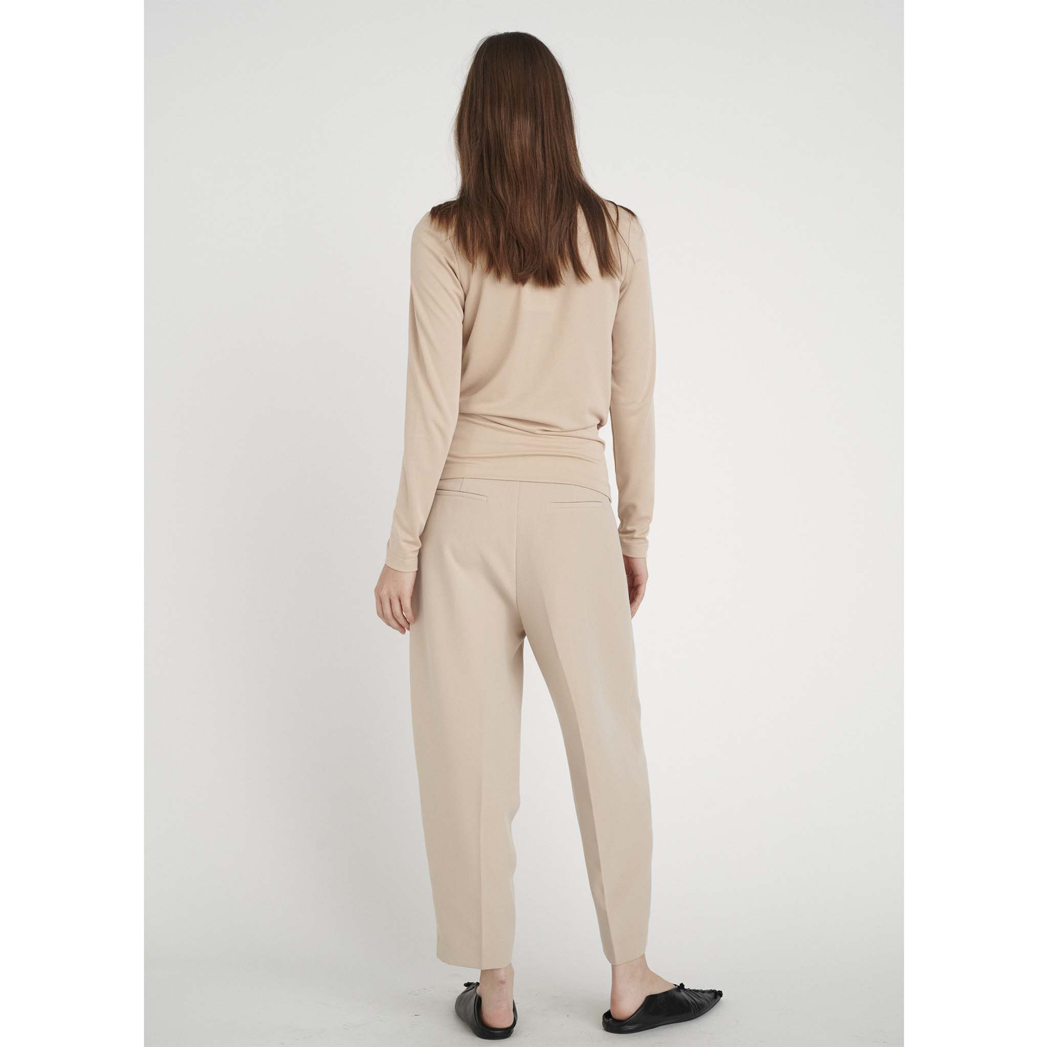 In Wear, naisten beige, pitkähihainen pusero. Kietaisutyyppinen malli, poimutusta helman sivuilla. Takakuva mallin päällä.