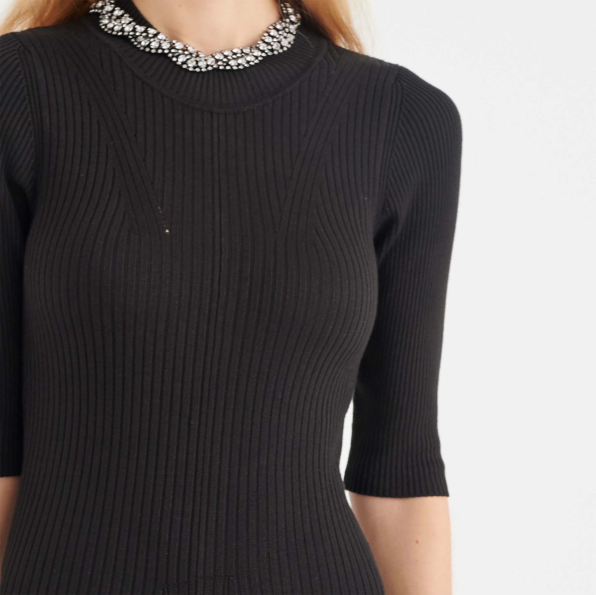 In Wear. Musta, pitkä, kapealinjainen neulemekko. Lähikuva mallin päällä.
