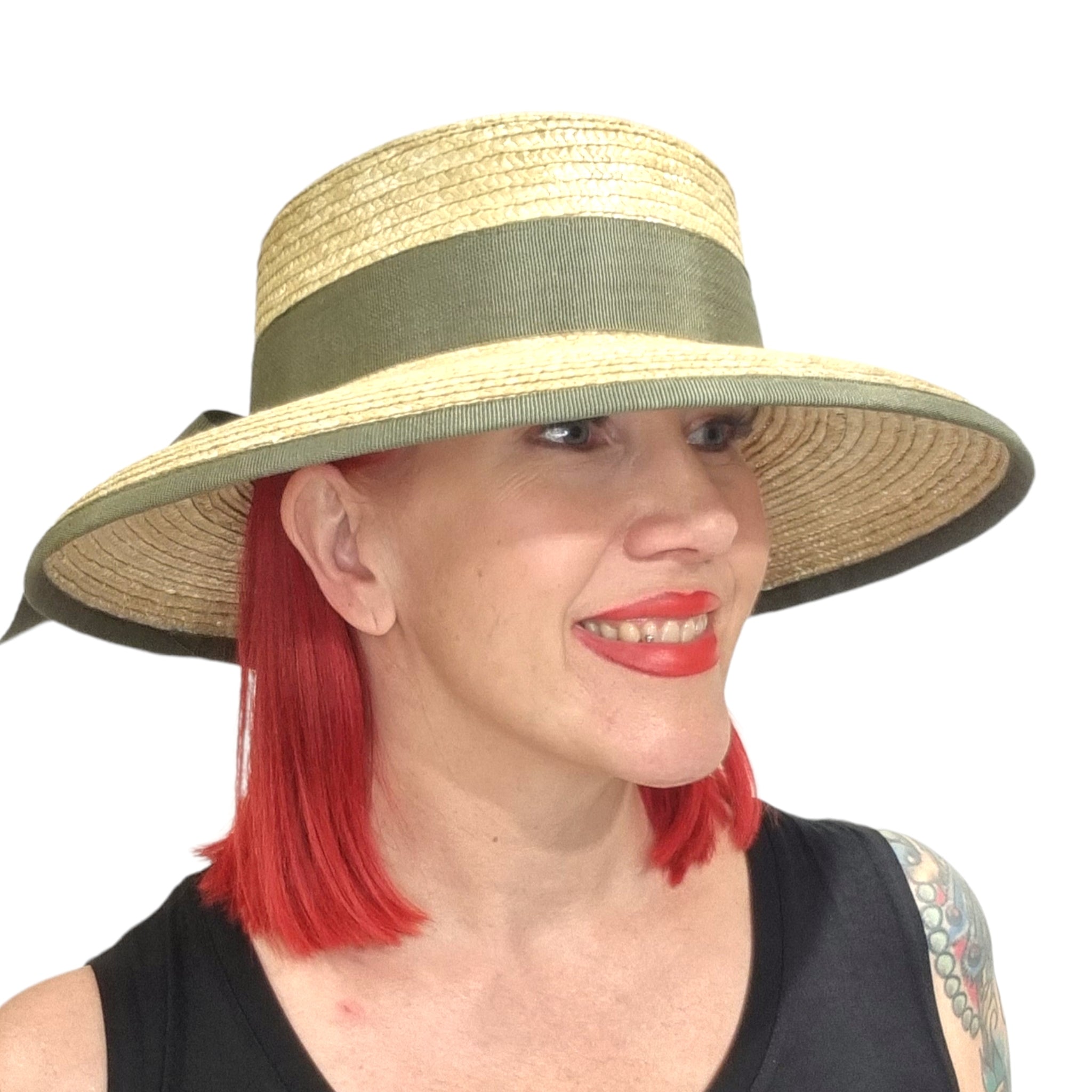 Kati Niemi, olkihattu, jossa on vihreä ripsinauha ja rusetti. Kuva mallin päässä.