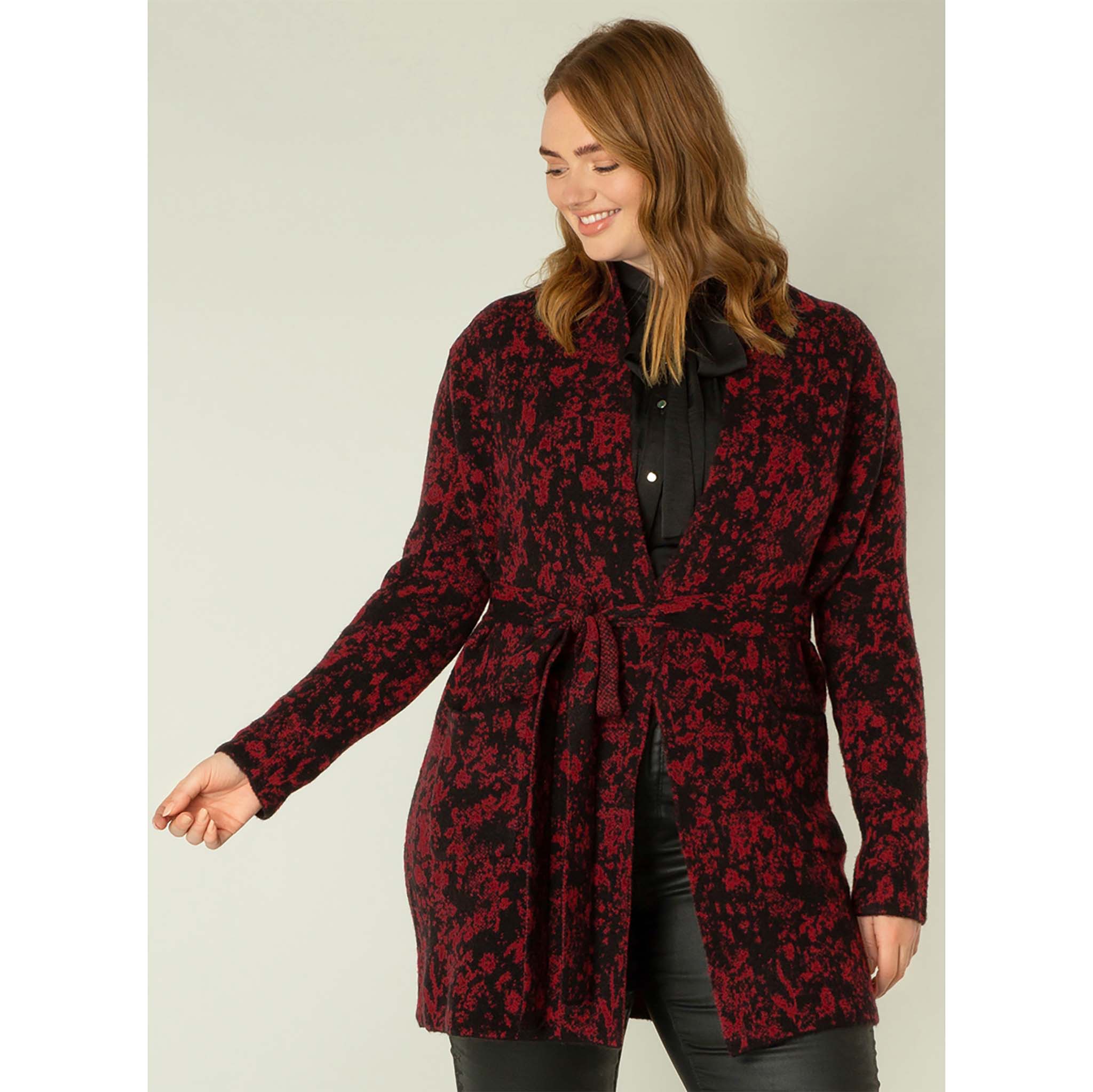 Yest, naisten kuviollinen neuletakki. Värissä viininpunaista ja mustaa. Solmittava vyö ja edessä taskut. Etukuva mallin päällä.